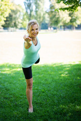 Ältere frau in sportlichem Outfit macht Übungen im Park 