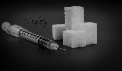 Insulin syringes and sugar are isolated on a black backgro.Diabetes