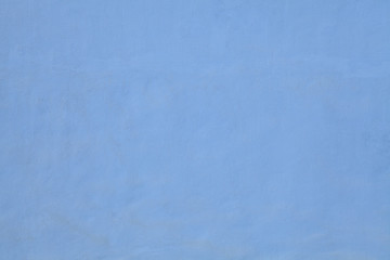 Blue wall, texture, background. The building wall, painted with water-based paint. Smooth (flat) surface in blue color