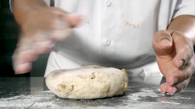 video of the hands of a man preparing sourdough bread with nuts and raisins
