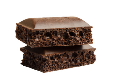 Two pieces of porous chocolate on a white background