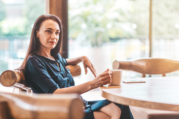 Coffee break. Business lady drinking coffee in the office. Copy space in upper right part