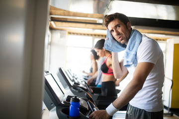 Fototapeta premium People running on treadmill in gym doing cardio workout