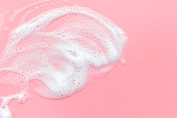Washing concept. Foam frame on pink top view copy space.