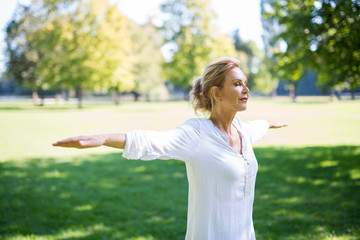 Frau macht Meditationsübungen im Park 
