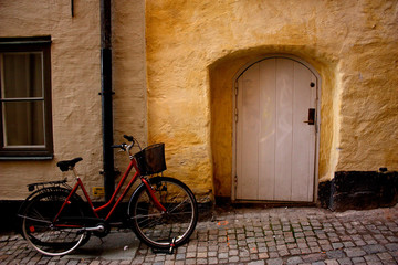 Fototapeta na wymiar A bicycle parked at a door in old town on a stone street.