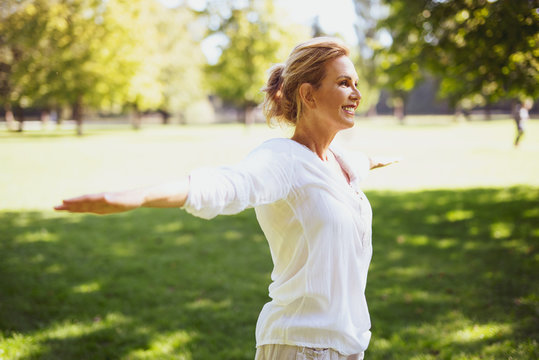 Attraktive Frau im mittleren Alter macht Übungen im Park