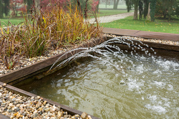 Water pool with nozzles shoting water outdoor.