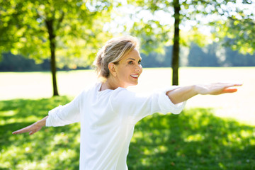 Attraktive ältere Frau macht Übungen im Park 