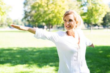 Attraktive ältere Frau macht Übungen im Park 