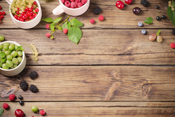 different berries on old wooden background