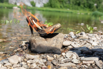 Burning shoes, high heel shoes. concept completion of youth and beauty. Air pollution caused by incineration. Black smoke.