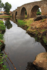 Fototapeta na wymiar Old stone bridge and reflection in the river, Spain
