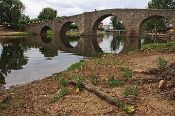 Old stone bridge and reflection in the river, Spain