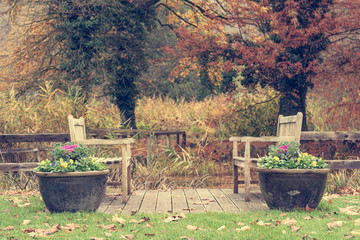Sitting area with pair of benches at a pond.