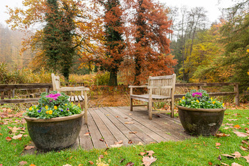 Sitting area with pair of benches at a pond.