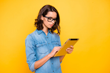 Turned photo of concentrated college girl in spectacles work on tablet search information for...