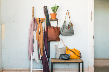 Group of leather bags and scarfs styled on ladder and table