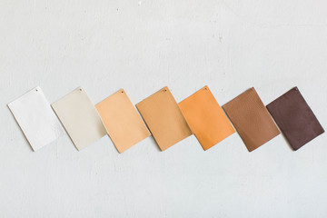 neutral brown leather cowhide swatches on white wall, copy space