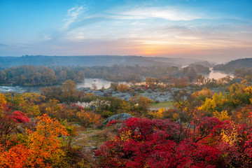 beautiful autumn landscape with colorful trees and foggy river on sunset