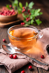 A cup of hot hawthorn tea made from freshly picked berries, herbal medicine for heart health