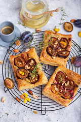 Delicious puff pastries with plums, honey, nuts, cinnamon and thyme