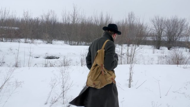 Adult man strolling through a snowy landscape