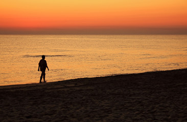 Fototapeta na wymiar Walking at dawn on the beach