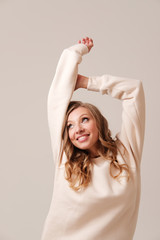 Studio portrait of young blonde stretching arms 
