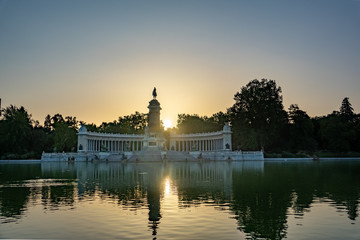 Fototapeta premium A lake and a Monument to Alfonso XII (build in 1922) in the public Park of the Pleasant Retreat (Parque del Buen Retiro) in Madrid, Spain