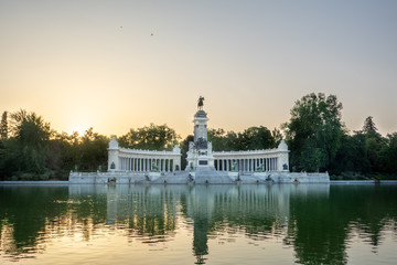 Fototapeta na wymiar A lake and a Monument to Alfonso XII (build in 1922) in the public Park of the Pleasant Retreat (Parque del Buen Retiro) in Madrid, Spain
