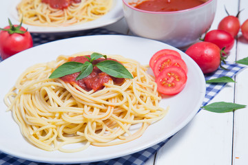 Spaghetti pasta with and tomato sauce on wood background