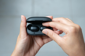 Close up of woman is open the black true wireless earbuds case