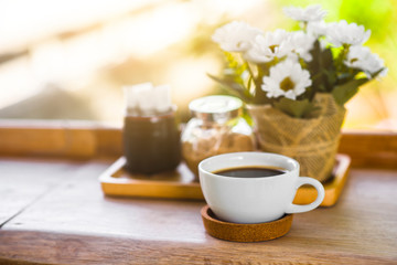  White coffee mugs and flower vases on a wooden table