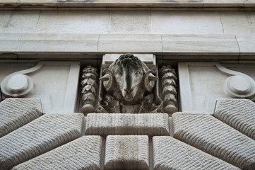 Stone goat head on the facade of the building