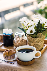  White coffee mugs and flower vases on a wooden table