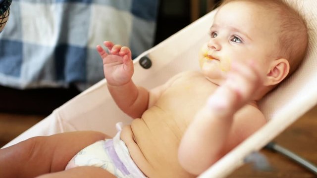 5 months old baby girl eating pumpkin porridge for the first time. Halloween concept. 