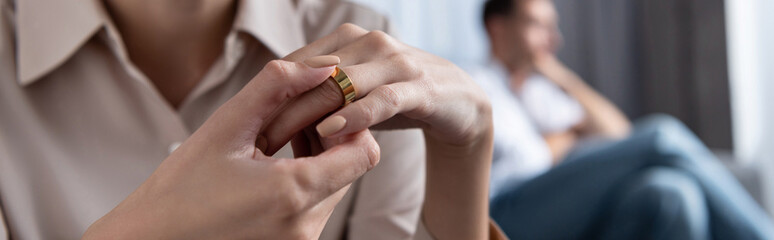 panoramic shot of woman in shirt taking off ring at home