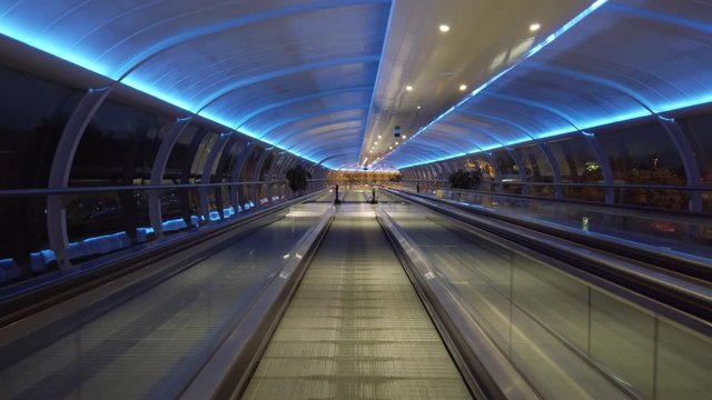Walking on airport walkway tunnel blue lights illumination.mov