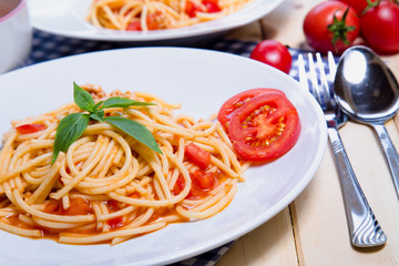 Spaghetti pasta with and tomato sauce on wood background