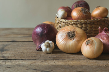 Fresh , organic onions in basket on old wooden table