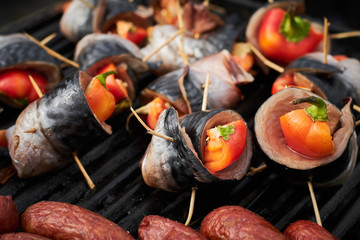 barbecue herring with tomatoes on open grill. street food