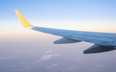 Fototapeta na wymiar Wing of an airplane on blue sky