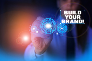 Text sign showing Build Your Brand. Business photo showcasing creates or improves customers knowledge and opinions of product Woman wear formal work suit presenting presentation using smart device