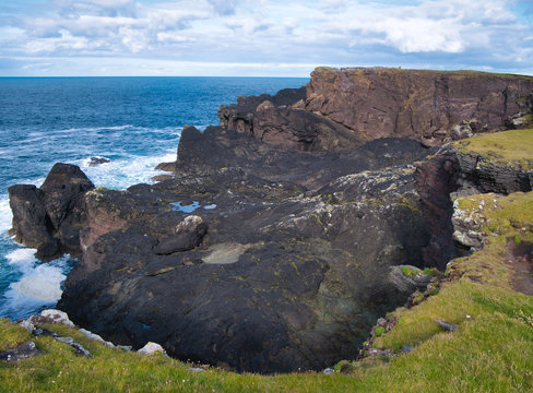 Coast rock formations at Eshaness on Shetland, Scotland, UK - the rocks are of the Eshaness Volcanic Formation - andesite, augite - igneous bedrock formed  in the Devonian Period. 