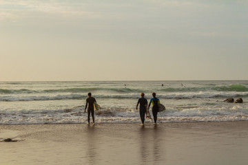 three surfers about to get into the water at Barrika Beach