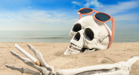 concept about cigarette addiction a skeleton with a cigarette lies on the beach