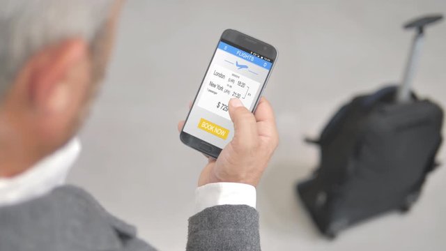 business man booking flight on his phone using smartphone application