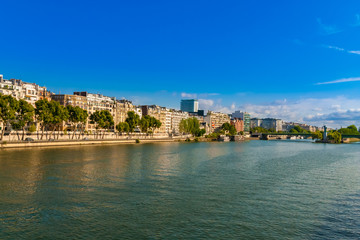 Beautiful panoramic view of the Quai Louis-Blériot, a quay alongside the Seine river in the 16th arrondissement of Paris, France on a nice day with a blue sky. The Île aux Cygnes can be seen from far.
