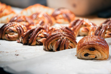Sweet pastries on the counter in the cafe, cinnamon rolls and chocolate. side view